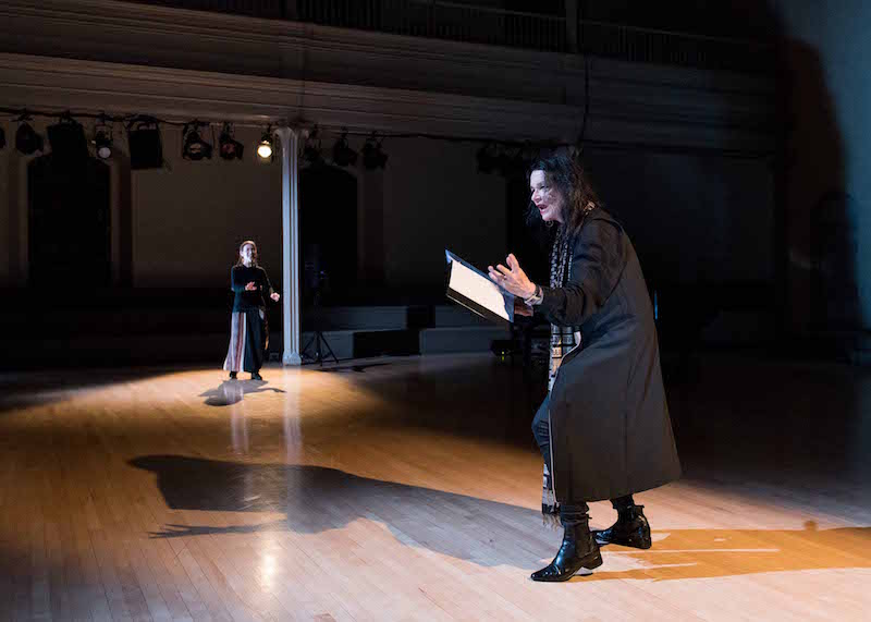 Monk and Waldman stand far apart on the Danspace stage. Waldman is in mid speech